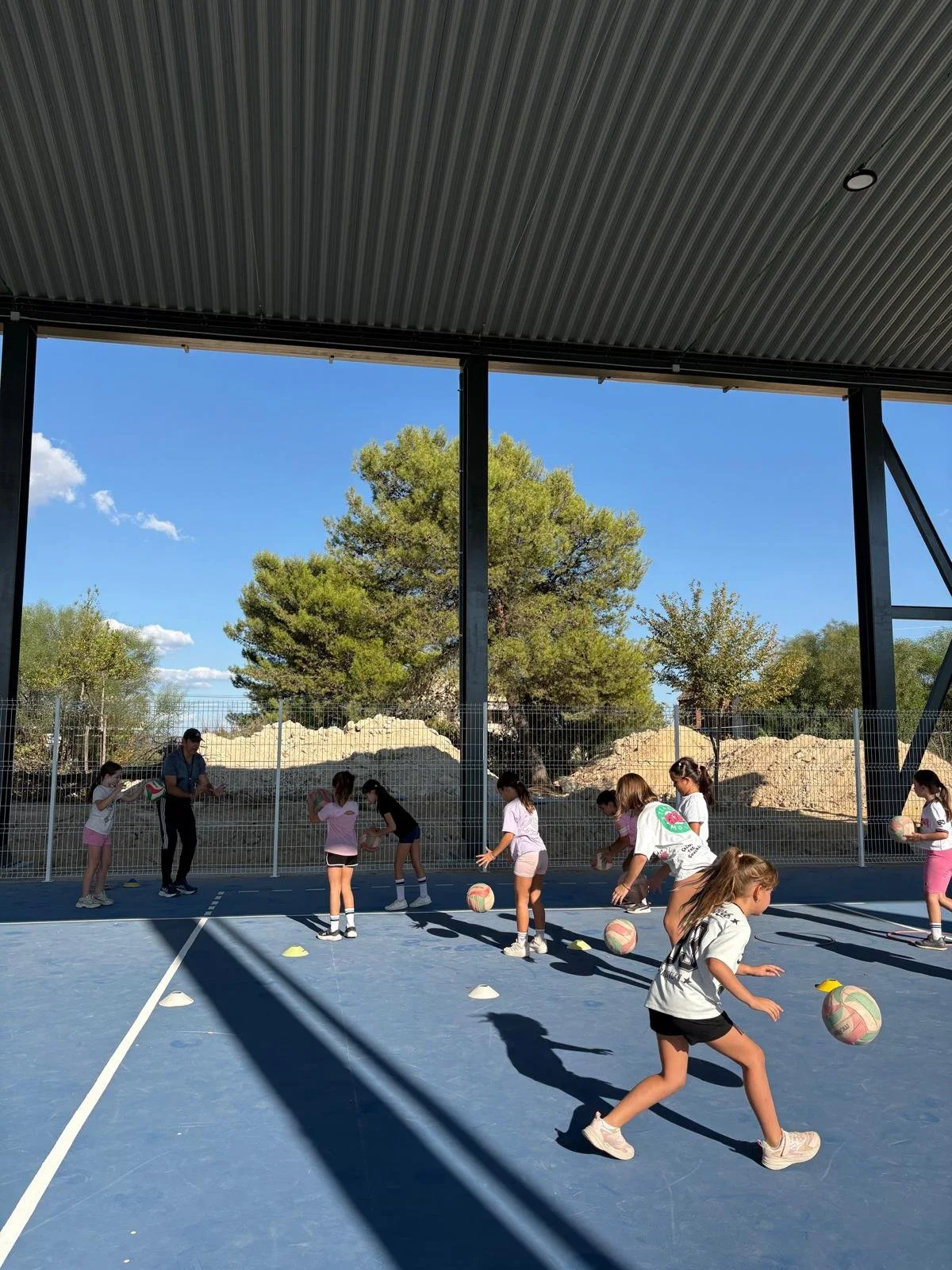 Children playing volleyball on an outdoor court in Las Pajanosas