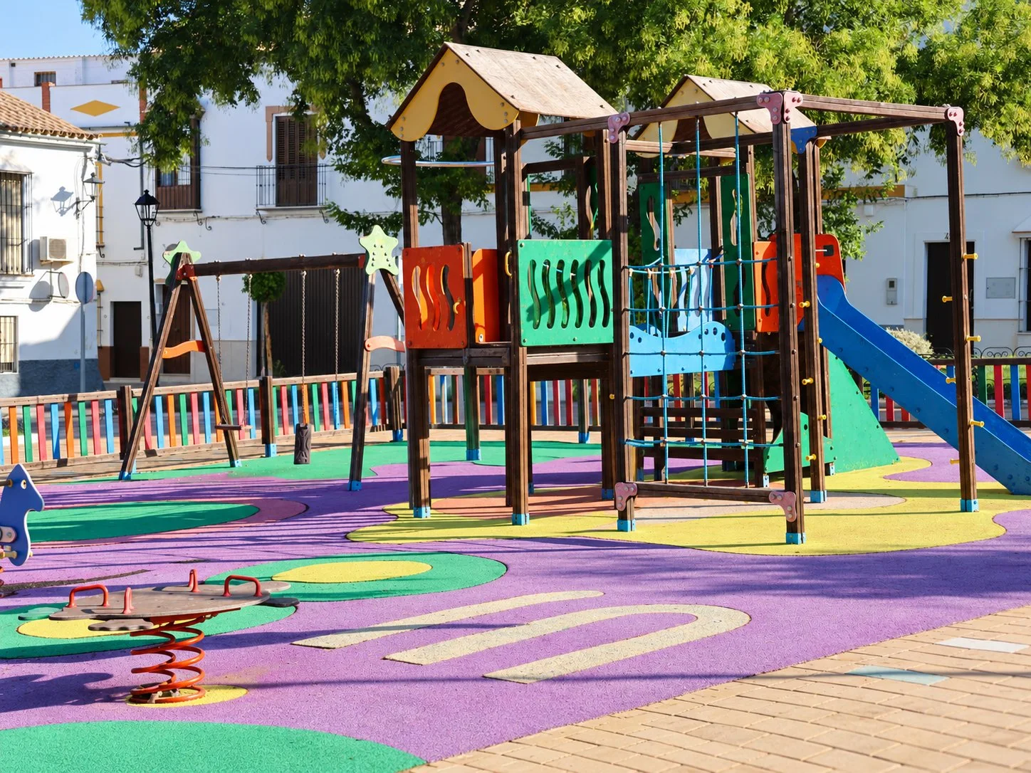 Osuna playground with coloured safety surfacing and play equipment